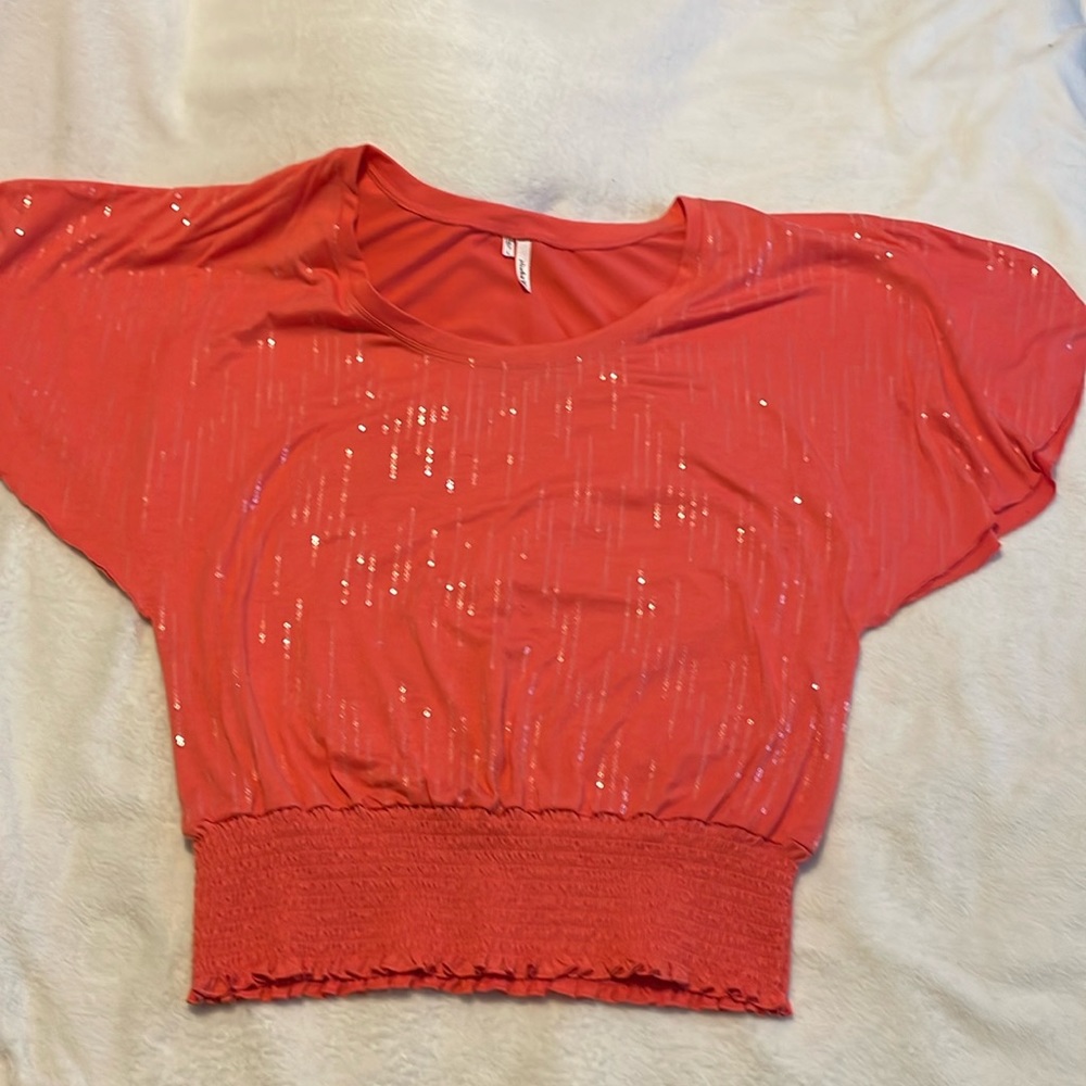 Salmon colored sequin Studio Y short sleeved shirt with elastic bottom, size L.